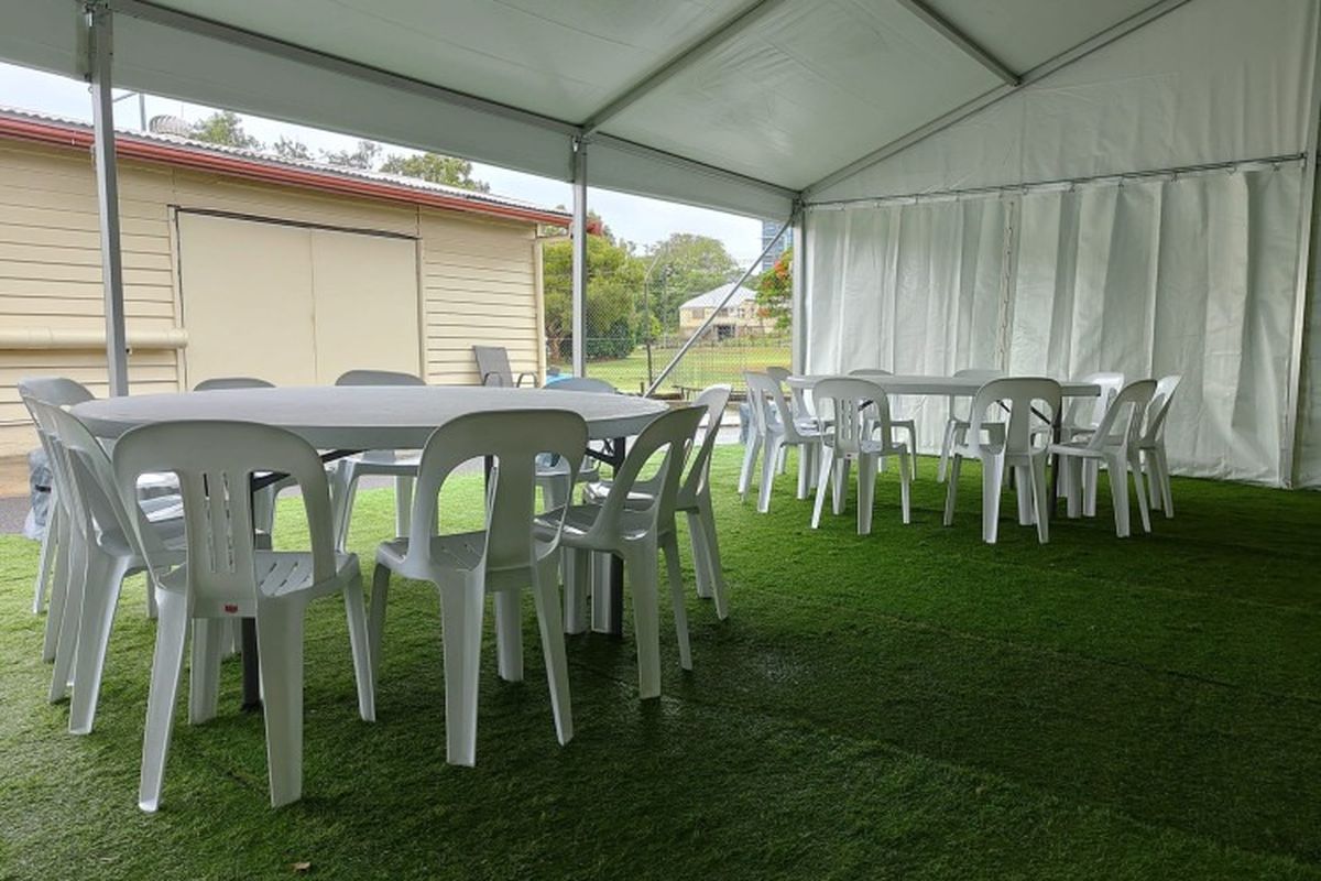Round banquet tables set for a wedding reception inside a marquee