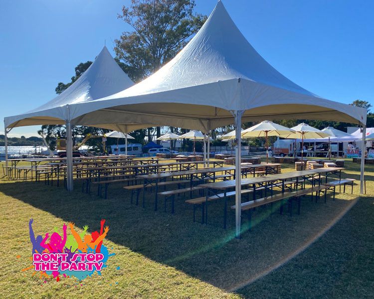 Large white pagoda marquee over long tables on a sunny lawn